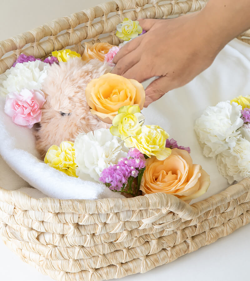 お花に囲まれた小さな家族を撫でるイメージ